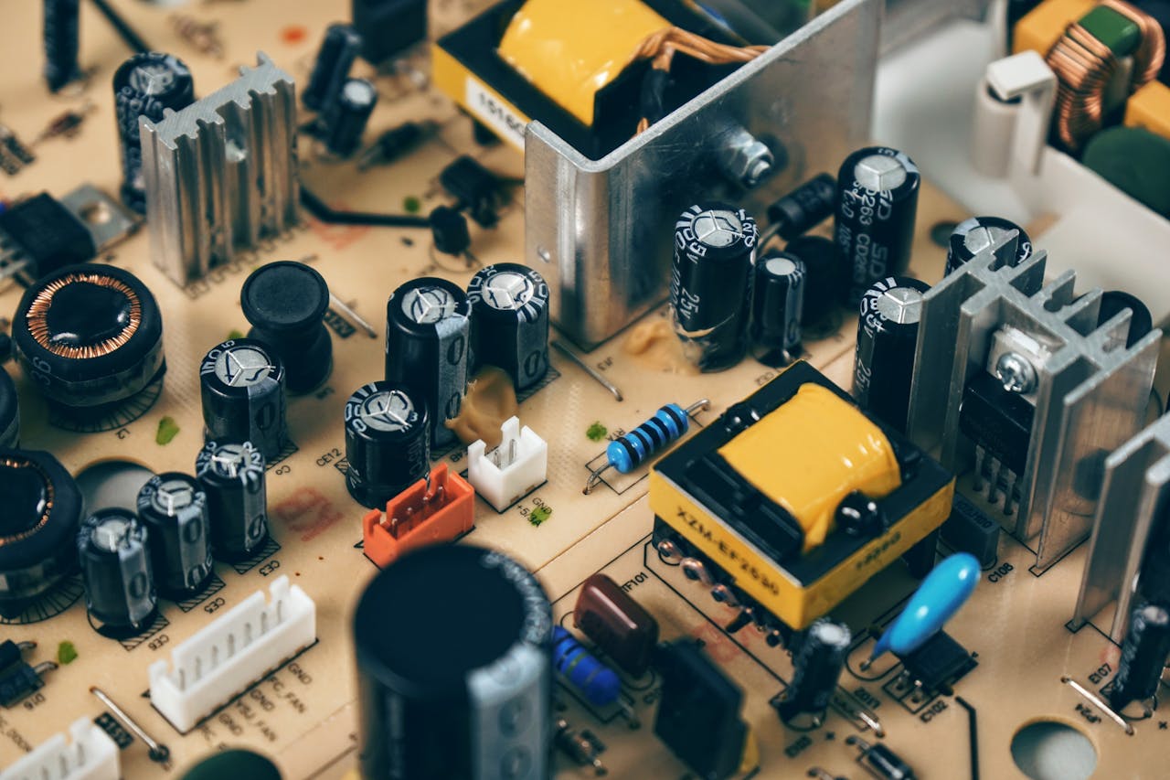 heros-img Detailed shot of capacitors and resistors on a circuit board, showcasing modern technology.